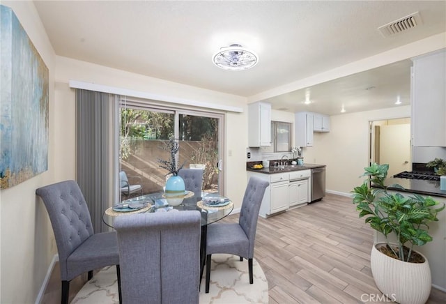 dining area featuring light wood-type flooring and sink