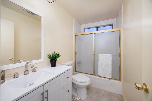 full bathroom featuring toilet, tile patterned floors, enclosed tub / shower combo, and vanity