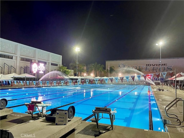 view of pool at twilight