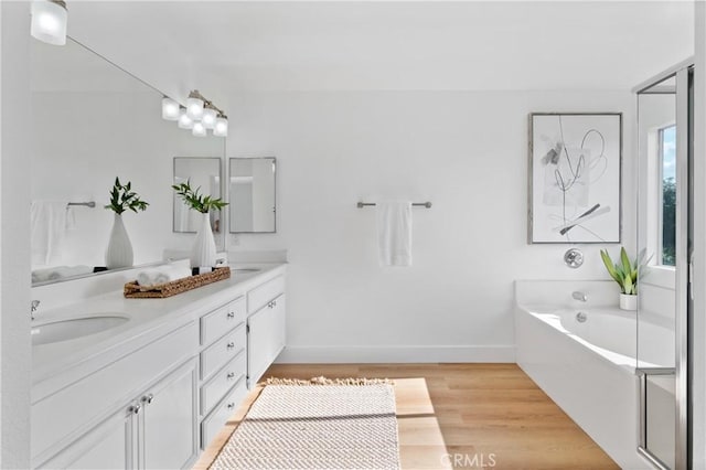 bathroom featuring hardwood / wood-style flooring, vanity, and a bathing tub