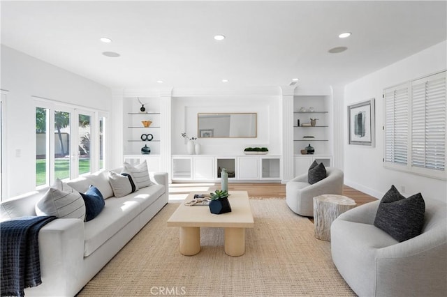 living room with built in features and light wood-type flooring