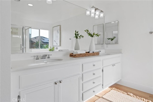 bathroom with a shower with door, vanity, and hardwood / wood-style floors