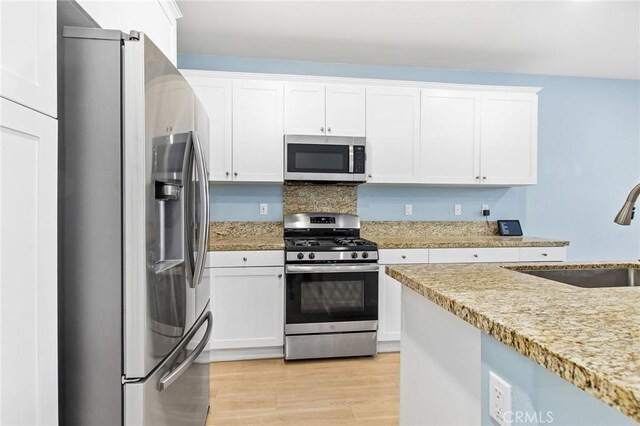 13946 Blossom Way, Eastvale, CA 92880 - kitchen featuring stainless steel appliances, a sink, white cabinets, and light wood-style floors