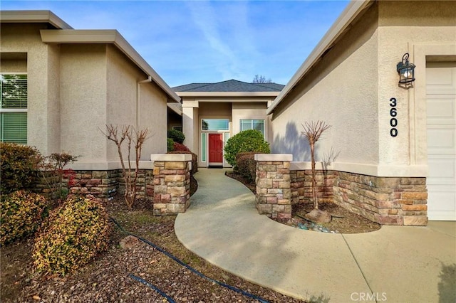 3600 Laver Ct, Redding, CA 96002 - doorway to property featuring stucco siding, stone siding, and an attached garage