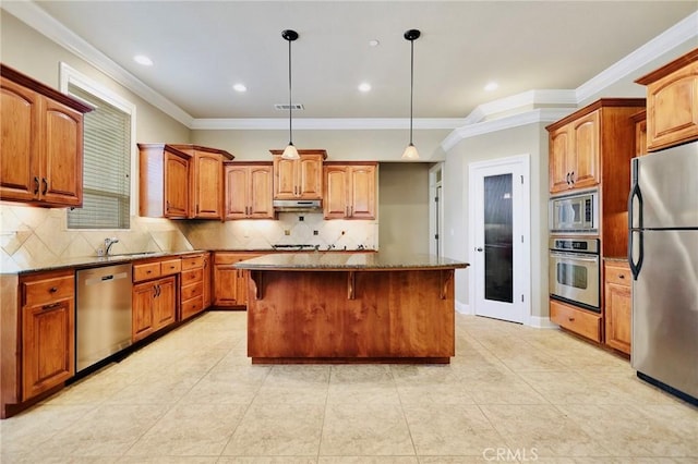 3600 Laver Ct, Redding, CA 96002 - kitchen featuring appliances with stainless steel finishes, under cabinet range hood, a center island, decorative backsplash, and crown molding
