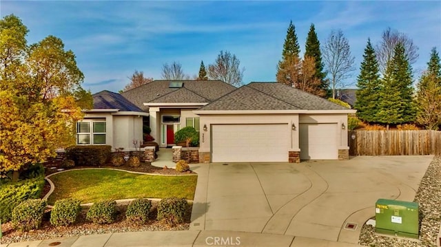 3600 Laver Ct, Redding, CA 96002 - view of front of house with stucco siding, a garage, concrete driveway, roof with shingles, and stone siding
