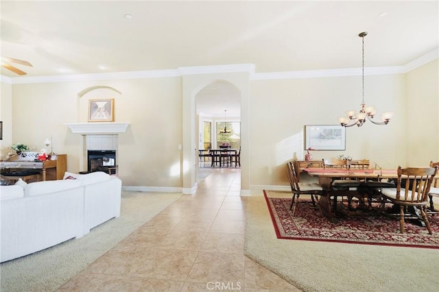 3600 Laver Ct, Redding, CA 96002 - dining area featuring ornamental molding, a chandelier, a tiled fireplace, arched walkways, and baseboards