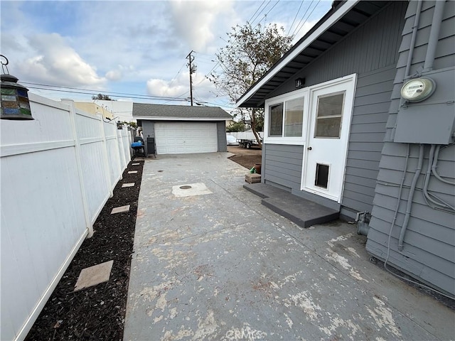 view of patio featuring a garage and an outbuilding