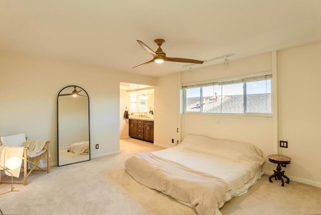 carpeted bedroom featuring sink, connected bathroom, and ceiling fan