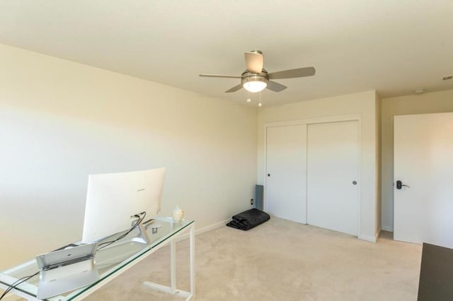 unfurnished office featuring ceiling fan and light colored carpet