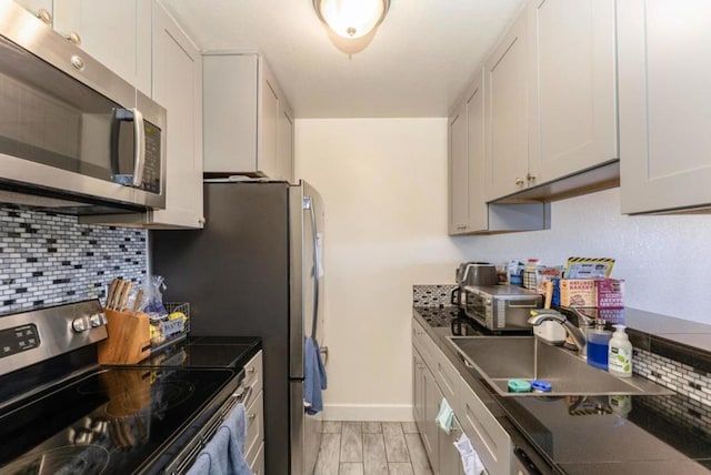 kitchen featuring white cabinetry, stainless steel appliances, and light wood-type flooring