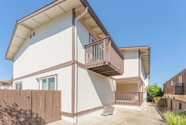 view of property exterior with a balcony and a patio