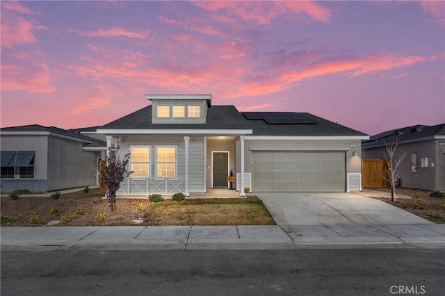 view of front of property featuring a garage and solar panels