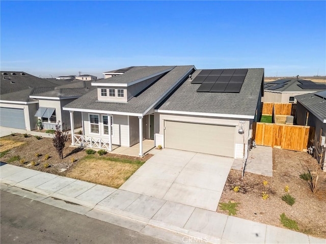 view of front of house with solar panels, covered porch, and a garage