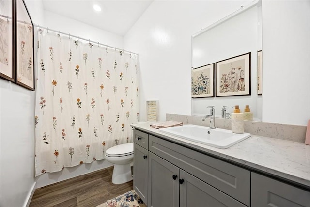 full bathroom with hardwood / wood-style flooring, toilet, vanity, and shower / bathtub combination with curtain