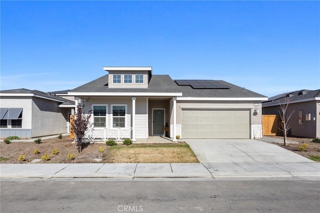 view of front facade featuring solar panels and a garage