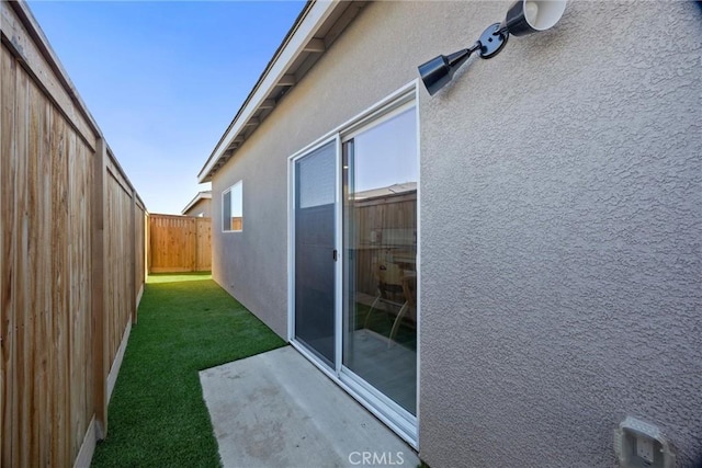 view of side of property with a patio area and a yard