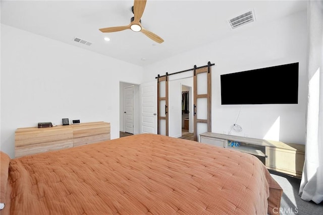 unfurnished bedroom with ceiling fan and a barn door