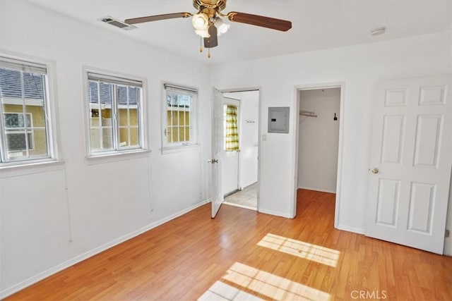 unfurnished bedroom featuring light wood-style flooring, a spacious closet, baseboards, and visible vents