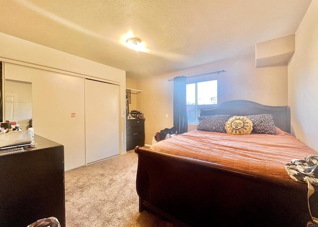 carpeted bedroom with a textured ceiling and a closet