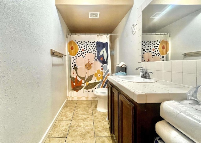 bathroom with toilet, vanity, backsplash, tile patterned floors, and a shower with curtain