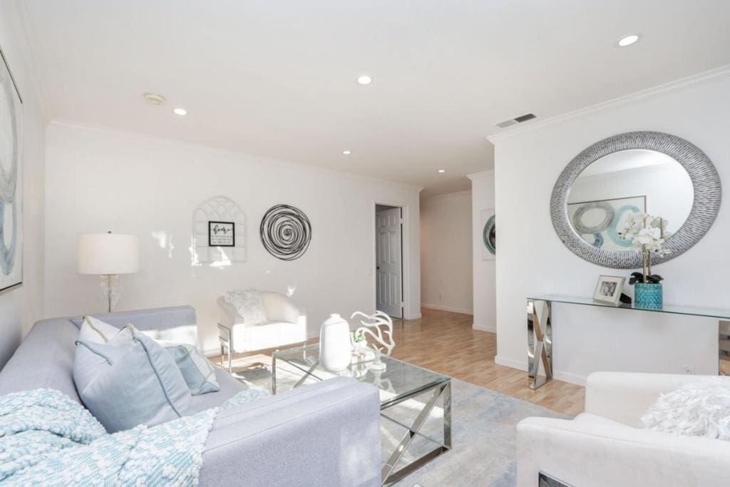 living room with ornamental molding and light hardwood / wood-style floors