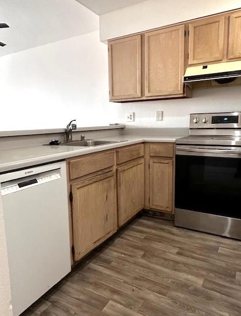 kitchen featuring sink, dark hardwood / wood-style flooring, white dishwasher, and stainless steel range