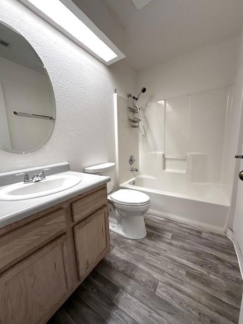 full bathroom with vanity, toilet, shower / tub combination, and wood-type flooring