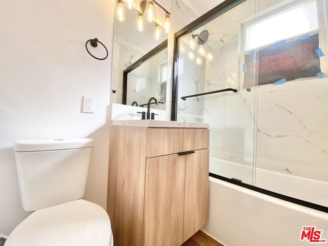 full bathroom featuring toilet, enclosed tub / shower combo, and vanity