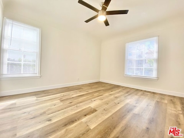 unfurnished room with light hardwood / wood-style floors, a wealth of natural light, and ceiling fan