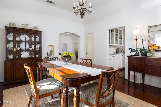 dining area featuring dark hardwood / wood-style flooring and an inviting chandelier