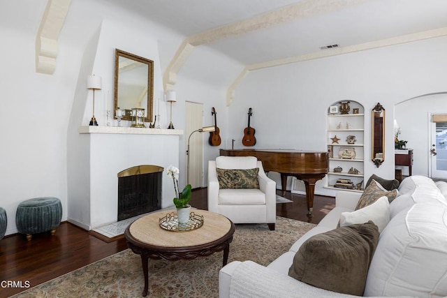 living room with built in shelves and dark hardwood / wood-style floors