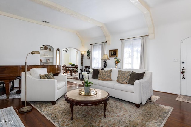 living room with vaulted ceiling, dark hardwood / wood-style floors, and built in shelves