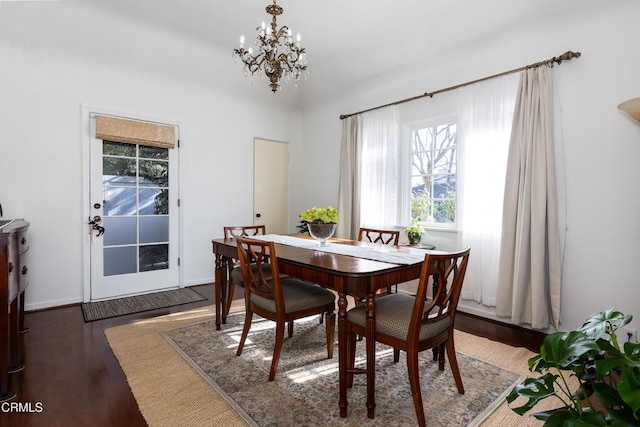 dining area featuring dark hardwood / wood-style flooring and an inviting chandelier