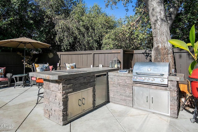 view of patio / terrace featuring an outdoor kitchen, area for grilling, and exterior bar