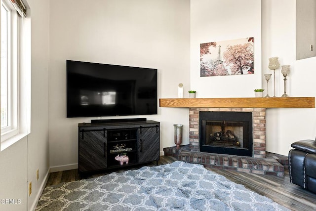 interior space with a brick fireplace and wood-type flooring