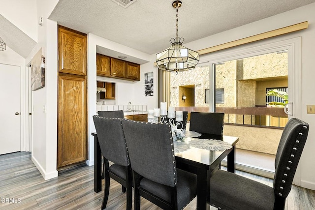 1014 S Marengo Ave Unit 3, Alhambra, CA 91803 - dining area with baseboards, an inviting chandelier, a textured ceiling, and wood finished floors