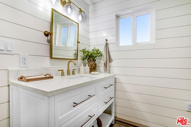 bathroom featuring vanity and wooden walls