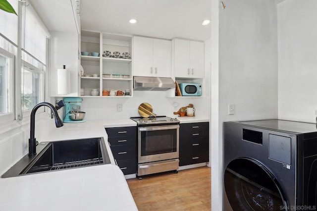 kitchen featuring white cabinetry, light wood-type flooring, stainless steel electric range, washer / clothes dryer, and sink