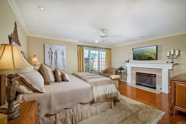 bedroom featuring ceiling fan, ornamental molding, and wood-type flooring