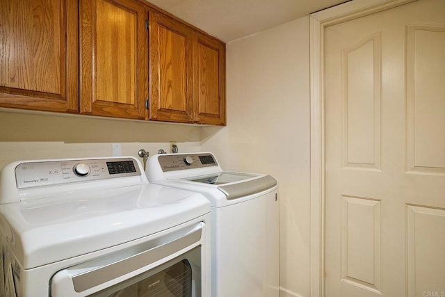 washroom with cabinets and washer and clothes dryer