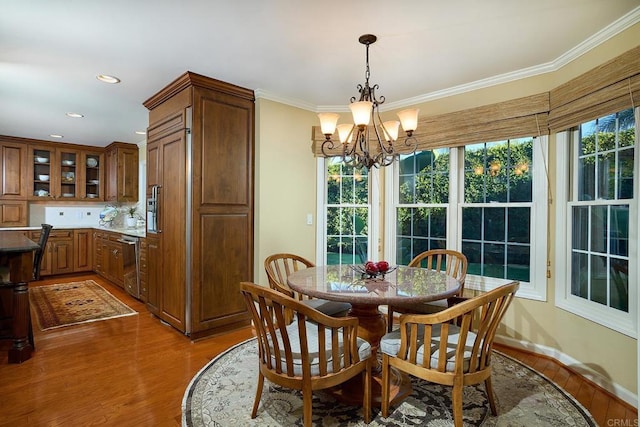 dining room featuring dark hardwood / wood-style floors, ornamental molding, and a notable chandelier