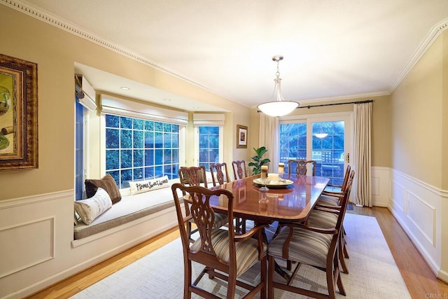 dining space featuring light hardwood / wood-style floors and ornamental molding