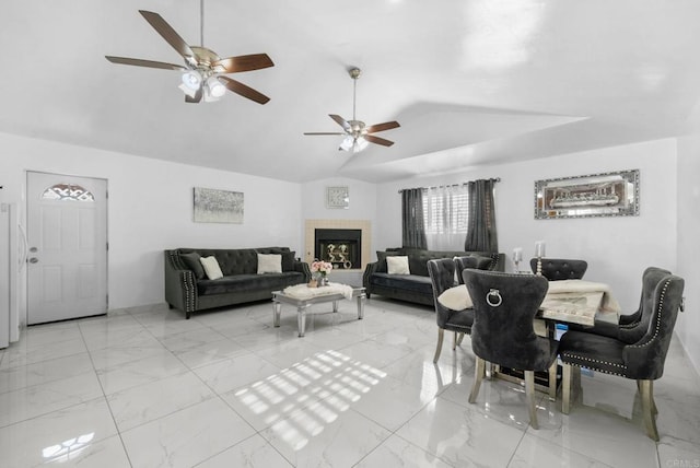 dining room featuring vaulted ceiling and a tiled fireplace