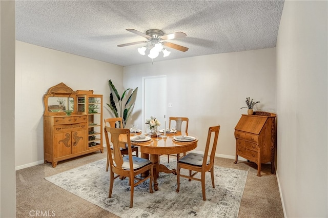 carpeted dining space featuring ceiling fan and a textured ceiling