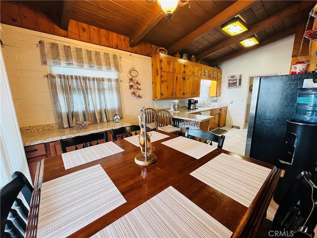 kitchen featuring vaulted ceiling with beams, brown cabinetry, a sink, and wood ceiling