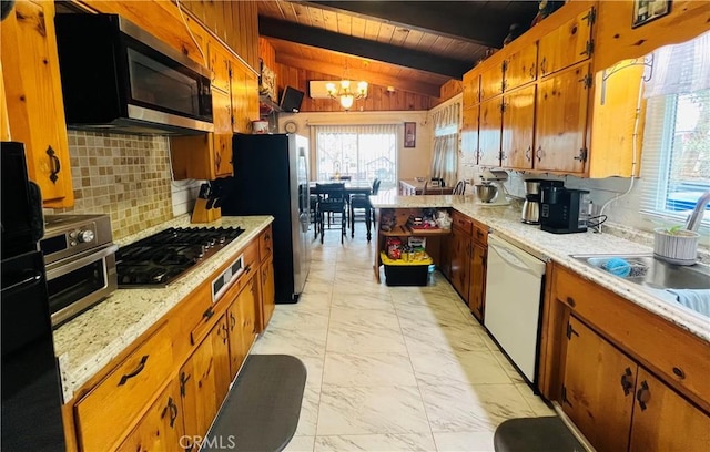 kitchen featuring lofted ceiling with beams, marble finish floor, appliances with stainless steel finishes, and brown cabinets