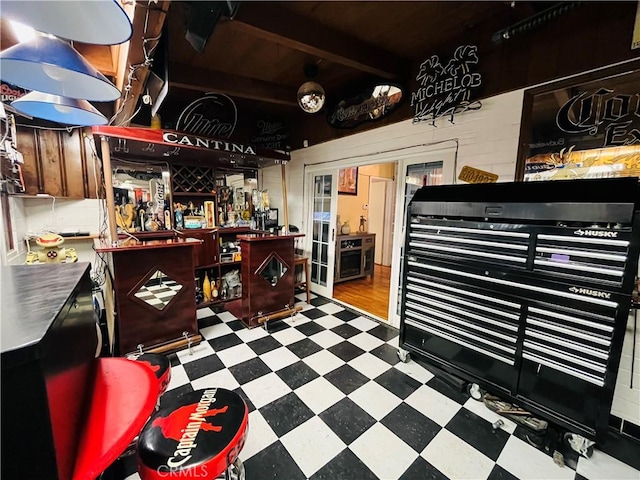 miscellaneous room featuring a bar, beam ceiling, and tile patterned floors