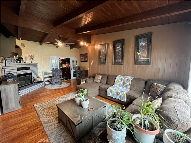 living room with wooden ceiling, light wood-style floors, a fireplace, and beamed ceiling