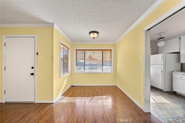 entryway with a textured ceiling, ornamental molding, and hardwood / wood-style flooring